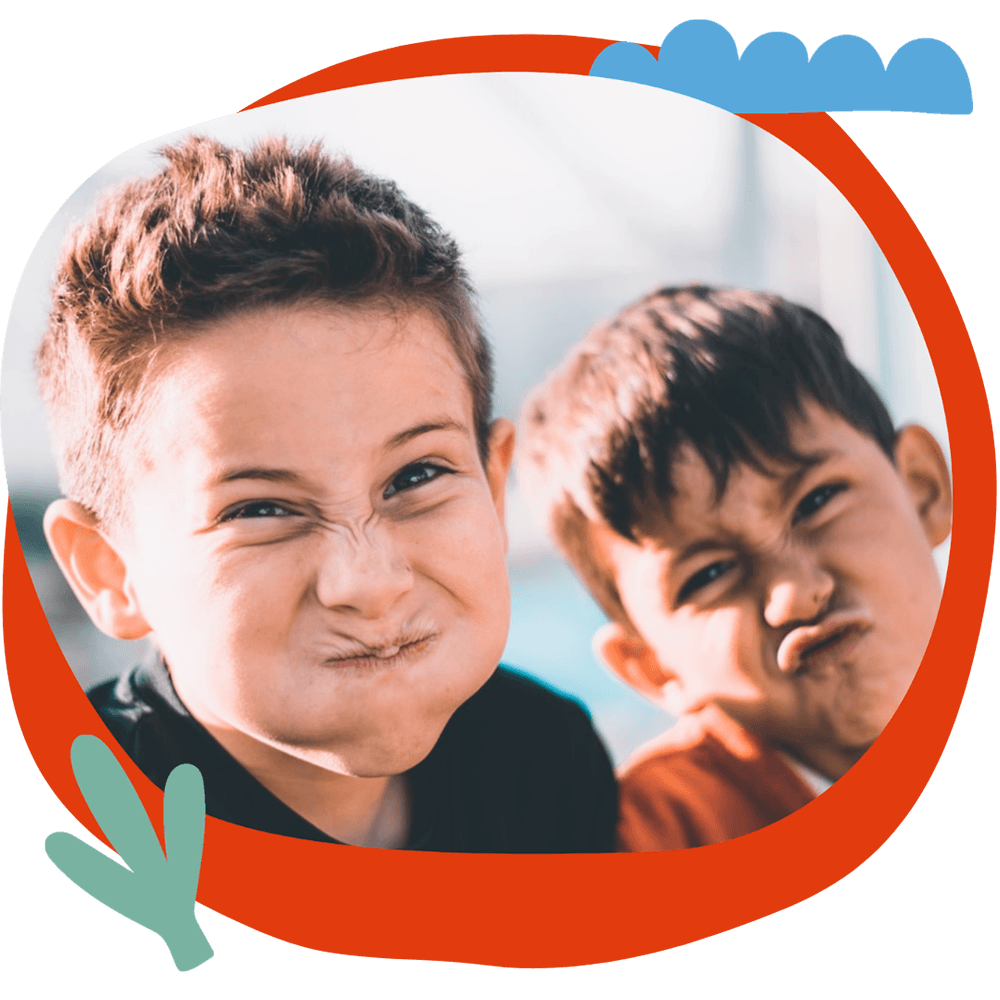 Due bambini che fanno smorfie buffe e divertenti, durante un momento di gioco del corso estivo Move Your Summer
