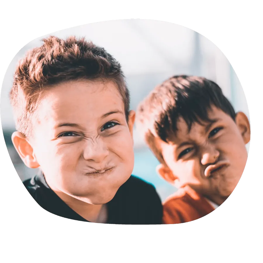 Due bambini che fanno smorfie buffe e divertenti, durante un momento di gioco del corso estivo Move Your Summer